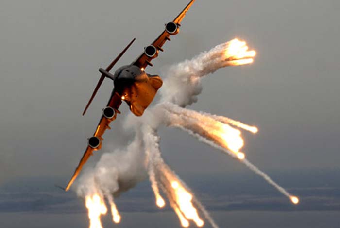 Boeing C-17 fires flares during a maneuver.