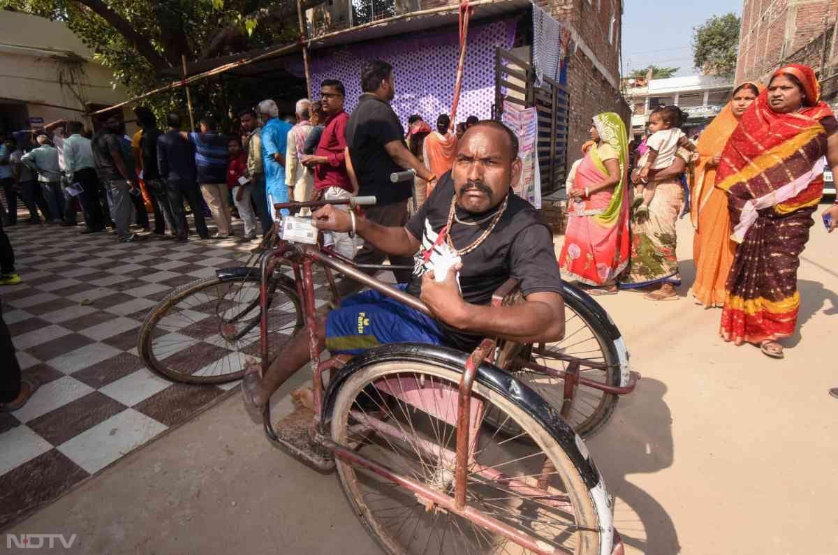 बिहार चुनाव के पहले चरण के दौरान पटना में एक शख्‍स व्हीलचेयर पर वोट डालने के लिए मतदान केंद्र तक पहुंचे.