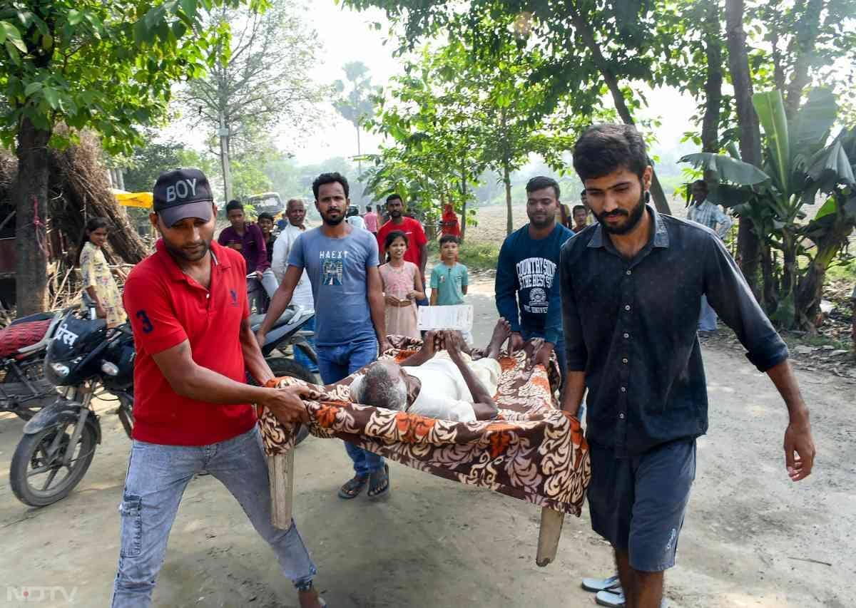 बिहार के मुजफ्फरपुर के बोचहा में एक बुजुर्ग मतदाता को खाट पर लादकर हाई स्कूल मतदान केंद्र तक पहुंचने में ग्रामीणों ने मदद की.