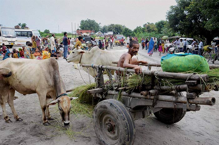 Flood affected villagers come out on the roads at Birpur on Sunday due to danger of flood after raised level of water in Kosi river after heavy inflow of water from Nepals side in Supaul disrict of Bihar.