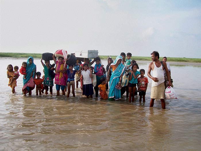 Villagers moving to safer places due to the danger to Kosis embankments after heavy flow of water into the river from Nepals side in Supaul, Bihar on Sunday.