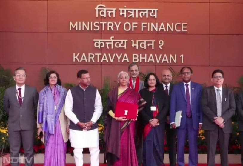 इस साल वित्त मंत्री निर्मला सीतारमण ने इस बार हाथ से बुनी कांचीवरम सिल्क साड़ी पहनी है, जो तमिलनाडु की पुरानी बुनाई से जुड़ी हुई है. साड़ी में हल्के सुनहरे भूरे रंग के चेक, यानी कट्टम, और धागे के काम के साथ कॉफी ब्राउन बॉर्डर है.