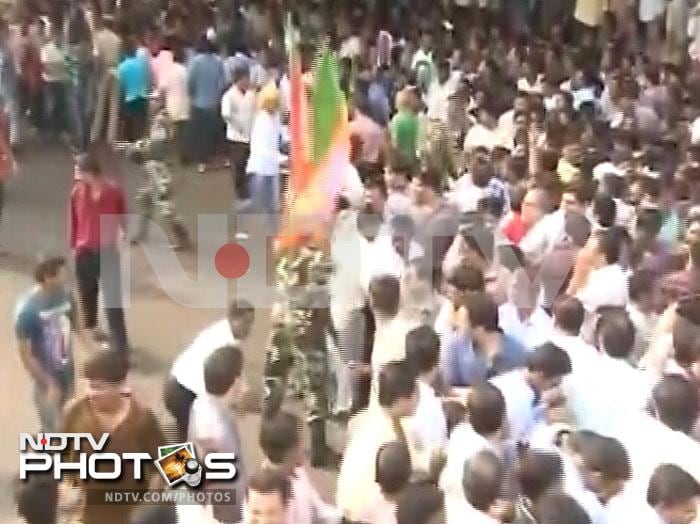 BJP supporters wave their party flags as they celebrate.