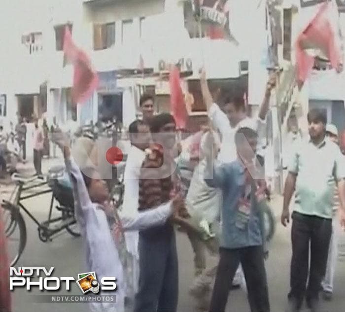 Samajwadi Party supporters dance on the street in Meerut.