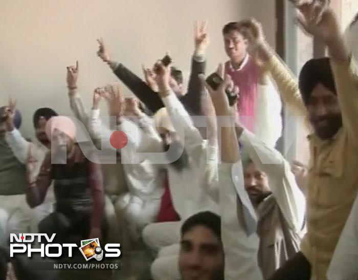 Shiromani Akali Dal supporters cheer as they watch the proceedings on television.