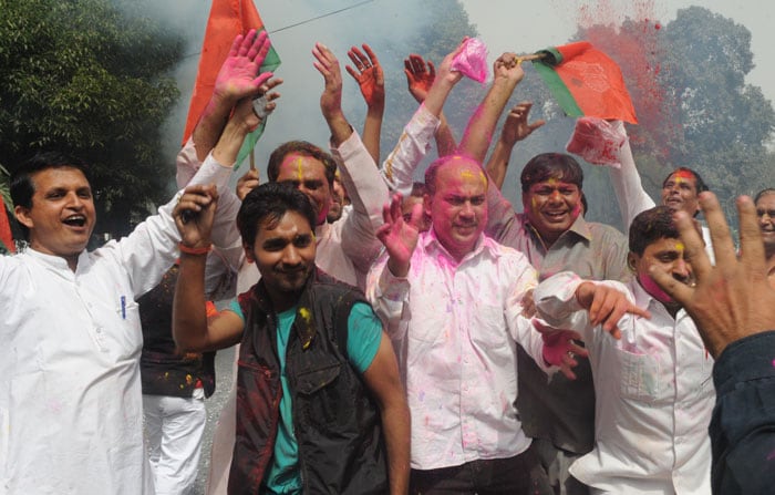 Samajwadi Party workers rejoice outside their party office in New Delhi.