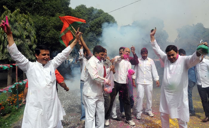 Samajwadi Party workers dance outside their office in New Delhi.