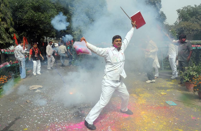 Samajwadi Party workers burst crackers outside their office in New Delhi.