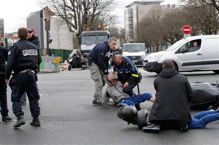 In this file photo police officers detain youth outside the kosher market in Paris on Friday. (Assocaited Press)