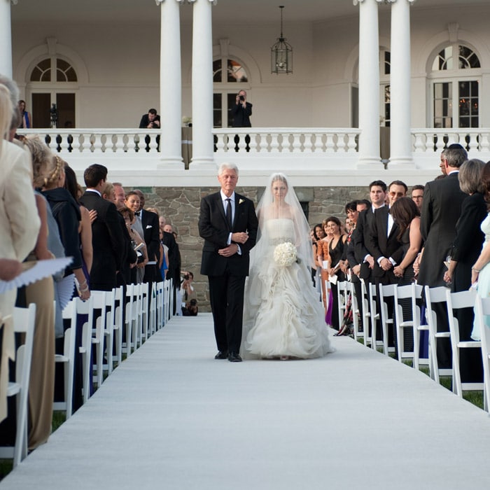 And finally as the time arrived, Chelsea the bride, dressed in all white, walked down the aisle with her father by her side.<br><br>In this picture the guests are seen gazing spellbound at the duo as Chelsea arrives with her father Former President Bill Clinton.(AP Photo)