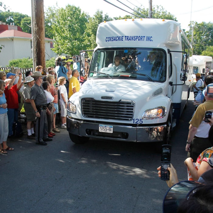 People gather at the street as guests leave the Delamater Inn on a special caravan hired exclusively to ply guests to the wedding venue. (AP Photo)