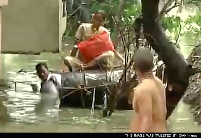 People were seen climbing out of their homes or climbing onto floating barrels.