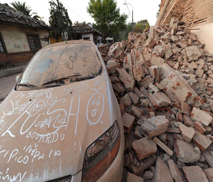 Chilean President Michelle Bachelet declared a "state of catastrophe" in central Chile and said the country would accept some of the offers of aid that have poured in from around the world.<br><br>Seen here, a car next to rubble in Curico, 250 km south of Santiago.(AFP Photo)