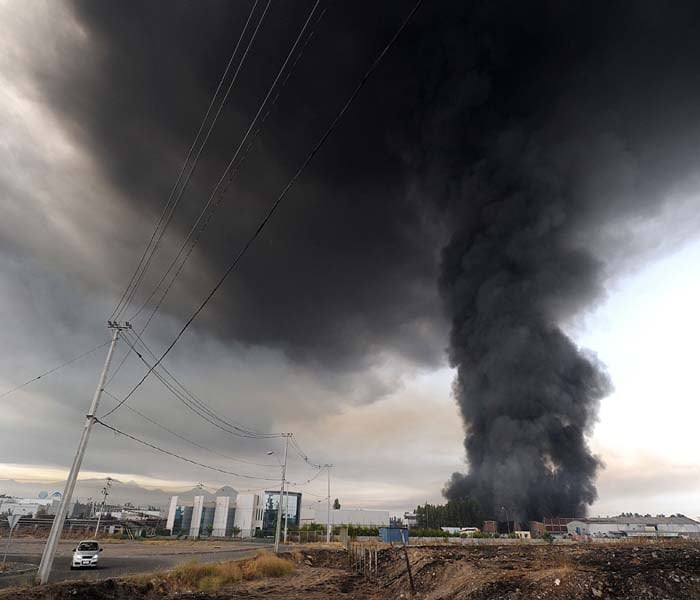 Smoke from a burning building fills the sky in the outskirts of Santiago after the devastating quake. (AFP Photo)