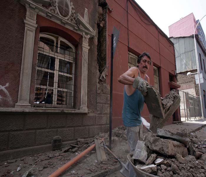 Seen here, a man cleaning the rubble in a street of Santiago following the catastrophic quake.(AFP Photo)