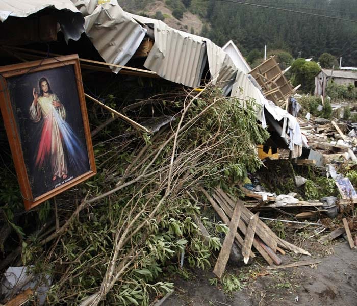 A beacon of hope : A painting of Jesus Christ hangs from a damaged house in Iloca, Chile.(AFP Image)