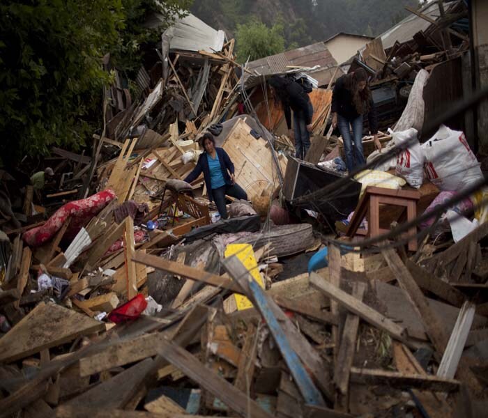 A family looks for belongings in what remains of their house in Constitucion.<br><br>The house was pushed some 200 meters from where it originally stood by a tsunami that was caused by Saturday's earthquake.(NYT Photo)