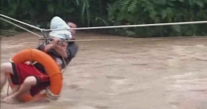 In this picture, baby being rescued by the soldier in the in the middle of fast-flowing floods full of weeds, with rescuers trying to get hold of him to pull him up.(AP Image)