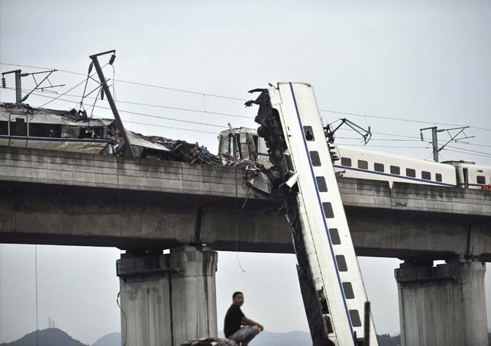 Tragedy struck China as a bullet train crashed into another high-speed train in the eastern part of the country on Sunday. The high-impact collision caused four carriages to fall off a viaduct and resulted in the death of 35 people and injured 191 others.<br><br>It was the first derailment on China's high-speed rail network since the country launched bullet trains in 2007 with a top speed of 155 miles (250 kilometres) per hour, the China Daily reported.<br><br>In this picture, a man sits by the wreckage of the train accident in Wenzhou in east China's Zhejiang province, Sunday, July 24, 2011. A Chinese bullet train crashed into another high-speed train that had stalled after being struck by lightning Saturday in eastern China, causing four carriages to fall off a viaduct. (AP Photo)