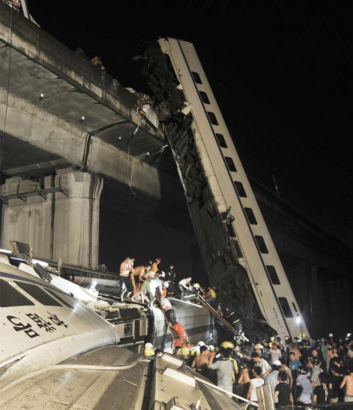 An official in the Zhejiang provincial emergency office said that 35 people had died, including one foreign female. He said her nationality was not clear. A further 191 people were being treated at hospitals, said the official, who gave only his surname, Hua, as is common with Chinese officials.<br><br>In this picture, emergency workers and people work to help passengers from the wreckage of train after two carriages from a high-speed train derailed and fell off a bridge in Wenzhou in east China's Zhejiang province Saturday July 23, 2011. (AP Photo)