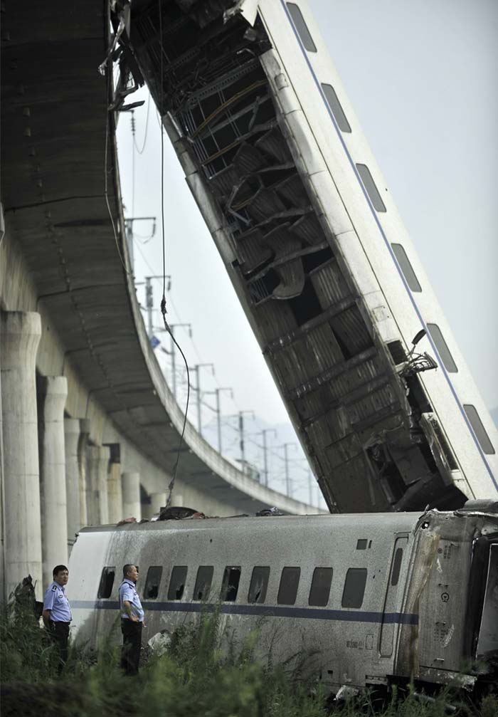 China has spent billions of dollars and plans more massive spending to link the country with a high-speed rail network. Power outages and other malfunctions have plagued the showcase high-speed line between Beijing and Shanghai since it opened June 30.<br><br>Official plans call for China's bullet train network to expand to 8,000 miles (13,000 kilometres) of track this year and 10,000 miles (16,000 kilometres) by 2020.<br><br>In this photo released by China's Xinhua news agency, a rescuer takes a picture of a train accident in Wenzhou, eastern China, Sunday, July 24, 2011. A Chinese bullet train crashed into another high-speed train that had stalled after being struck by lightning Saturday, causing four carriages to fall off a viaduct. (AP Photo/Xinhua, Ju Huanzong)