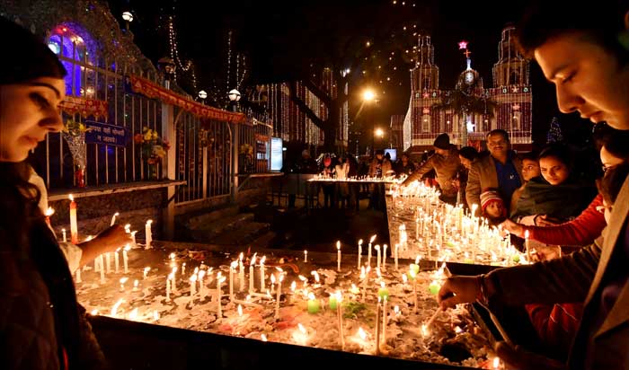 People light candles outside the Sacred Heart Cathedral in New Delhi to celebrate christmas. (PTI Photos)