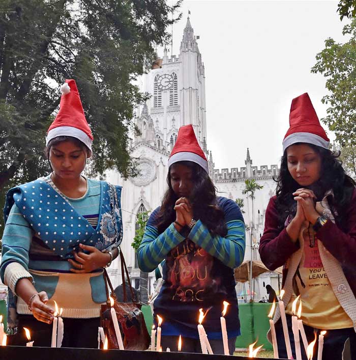 People lighting candles at St Pauls Cathedral during Christmas celebration in Kolkata. (PTI Photos)