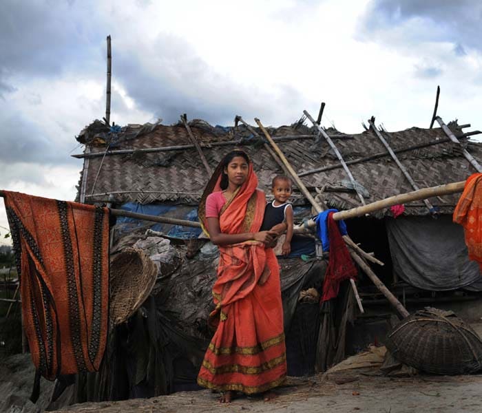 In this portrait taken on August 24, 2009, Suriya Begum, a slum dweller in the Bangladeshi capital Dhaka, holds her baby. The 18-year-old moved from the southern coast to Dhaka a few years ago in search of a better life because jobs are few and far between and fertile land is becoming scarce. Experts say the number of people moving to the city will balloon in the coming years because of climate change. (AFP photo)