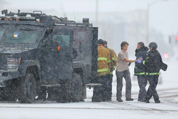 A woman is escorted from a police utility vehicle after being rescued during an active shooter situation near a Planned Parenthood facility where an unidentified suspect has reportedly injured up to eleven people in Colorado.