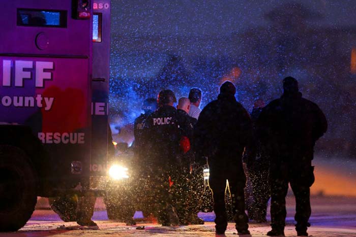 A suspect is led away in handcuffs by police during an active shooter situation outside a Planned Parenthood facility where an active shooter reportedly injured up to eleven people in Colorado.