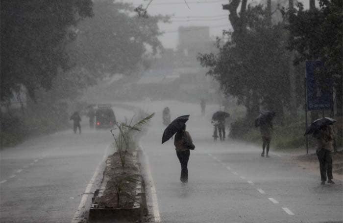 People hold umbrellas as they head to a cyclone shelter in Chatrapur in Ganjam district, about 200 kilometers from Bhubaneswar, Odisha.