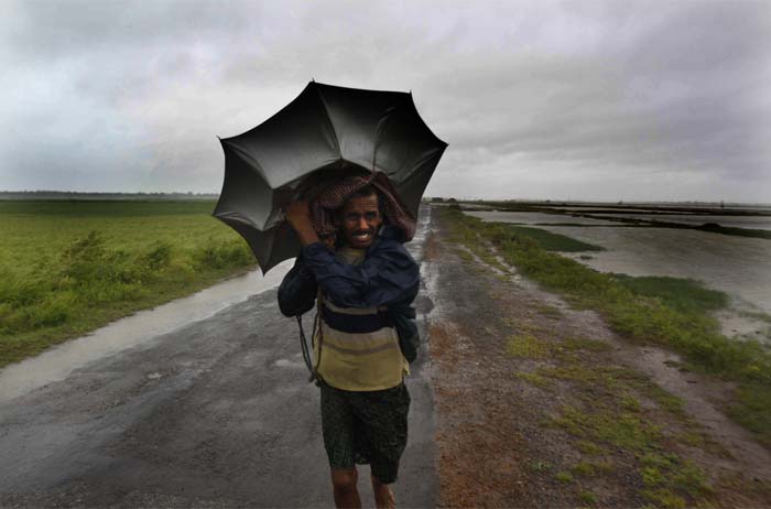 A villager braving strong winds and rain walks to a safer place, in village Podampeta, in Ganjam district about 200 kilometers from Bhubaneswar, Odisha.