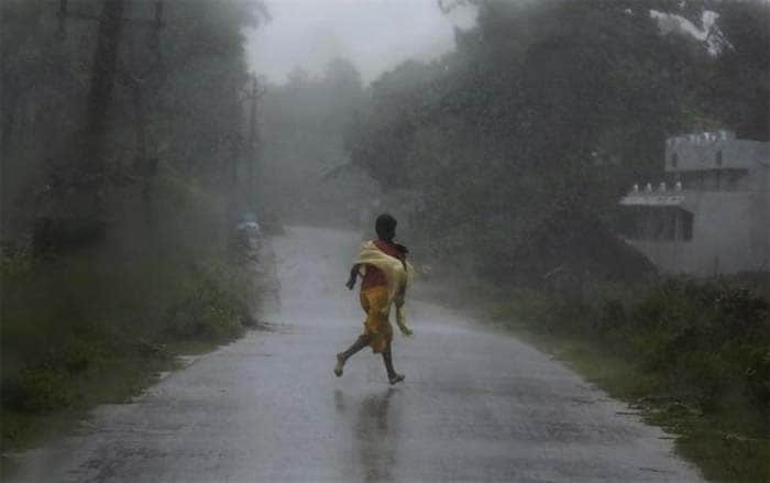 A girl runs for shelter in heavy rain brought by Cyclone Phailin in Ichapuram town in Srikakulam district in Andhra Pradesh.