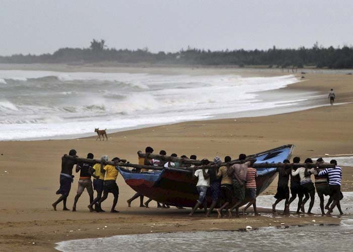 Fishermen move a boat away from the coast following cyclone Hudhud warning near Podampeta village in Ganjam district on Saturday.