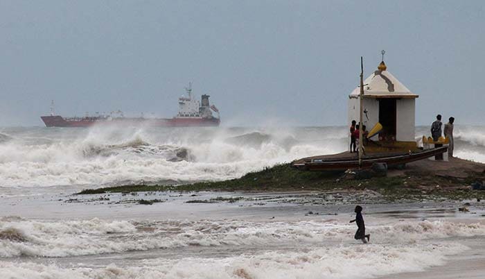 At the Vishakhapatnam coast in Andhra Pradesh, a boy wades in the surf hours before Cyclone Hudhud was to make landfall in Visakhapatnam.