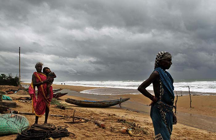 Asked to evacuate from Podampeta village on the outskirts of Odisha's Gopalpur, fisherwomen assess the sea.