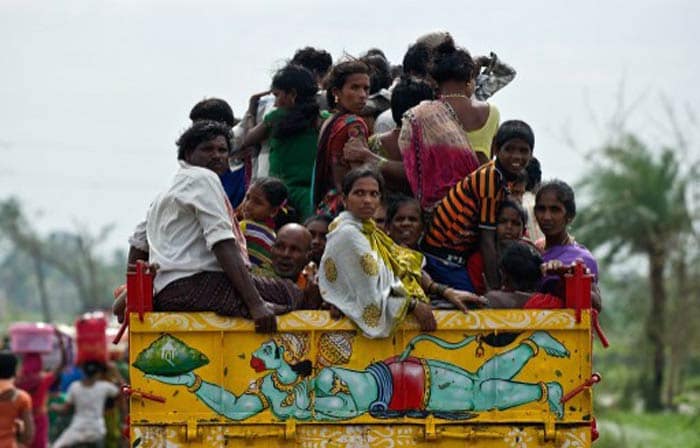 Prime Minister Manmohan Singh has directed that all possible assistance be extended to the states which are on alert for the cyclone. Seen here, people ride on the back of a tractor as they return to Sonupur village around 15 kms from Gopalpur in Odisha.