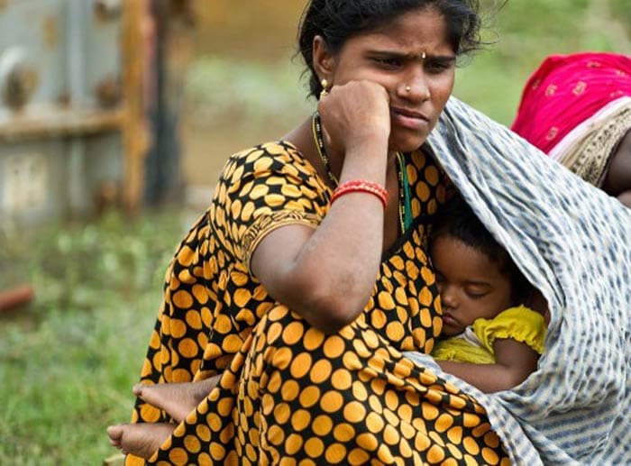 The cyclone remained "very severe" for six hours after hitting the coast. Seen here, a displaced woman covers her sleeping child as she waits to return at Sonupur village around 15 kms from Gopalpur in Odisha.