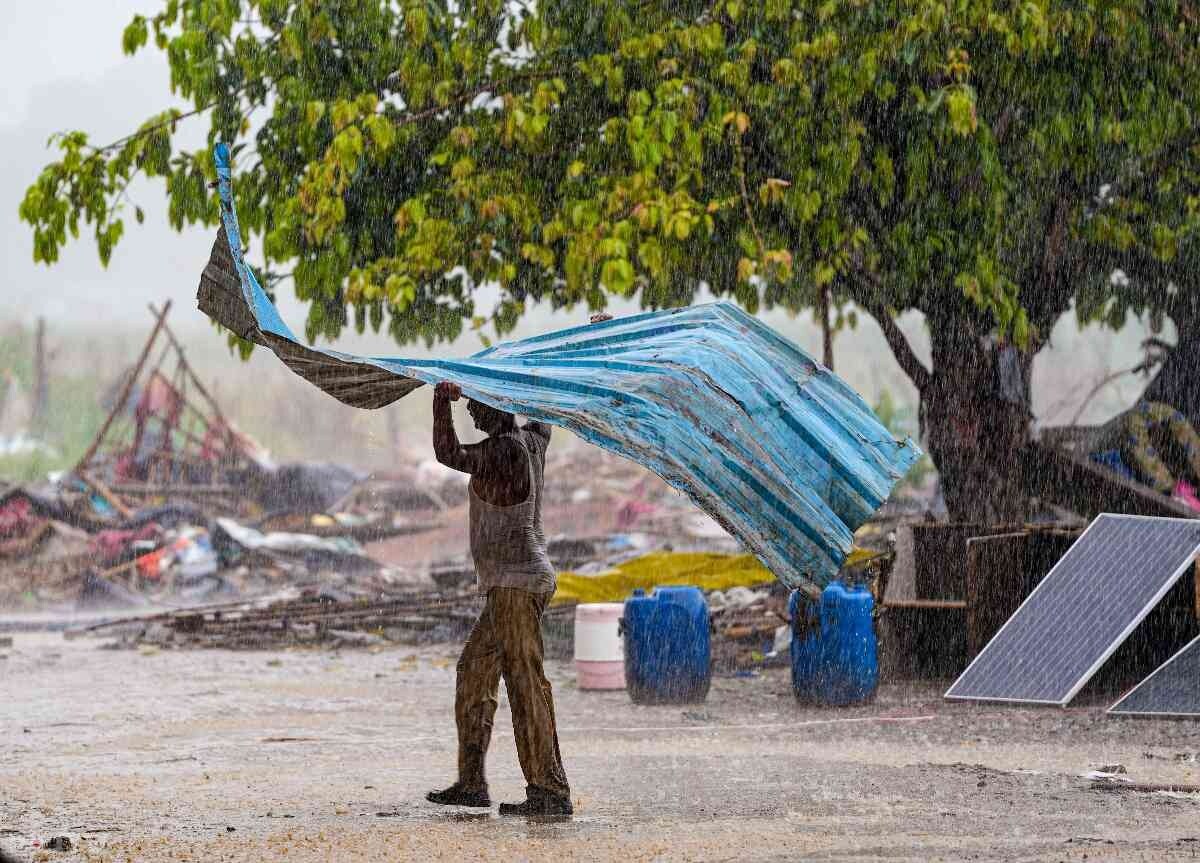 दिल्ली में हुई बारिश के दौरान तेज हवाएं भी चली. इस दौरान एक शख्स तिरपाल को हवा में उड़ने से बचाते हुए.