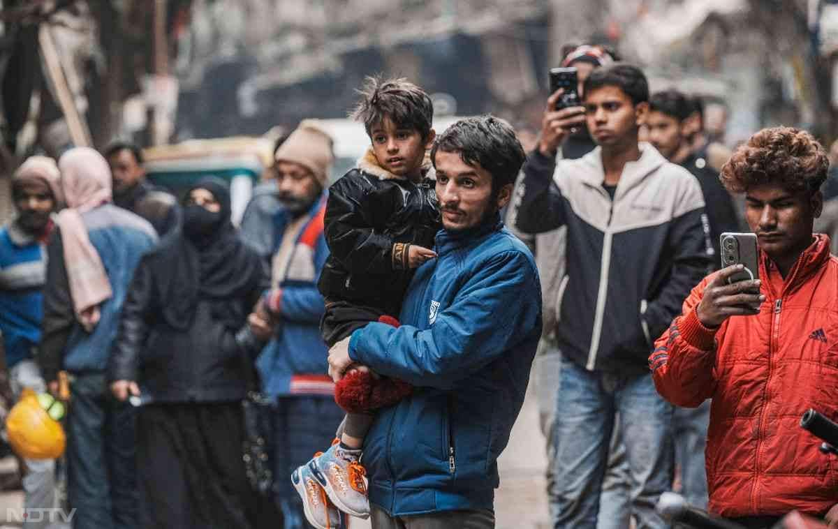 तोड़फोड़ के बाद के मंजर को कैमरे में कैद करते आसपास के लोग.