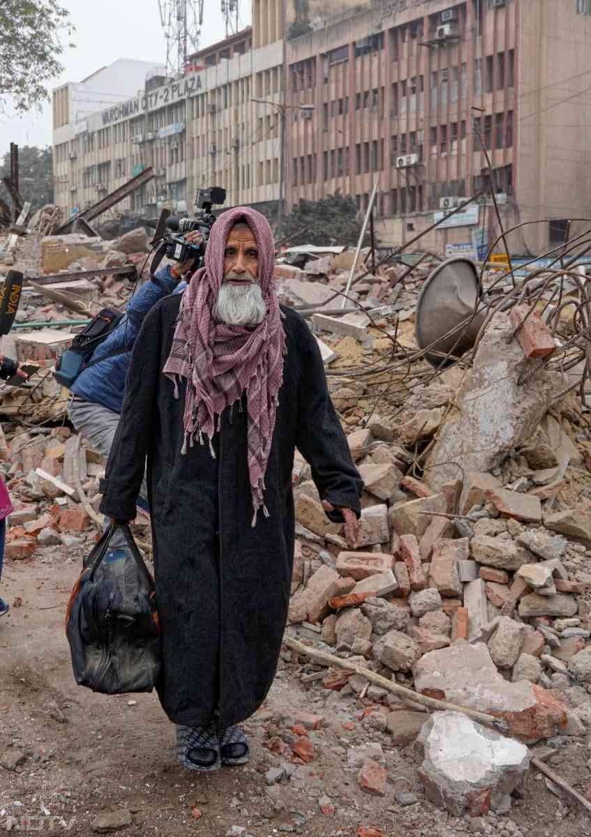 अवैध कब्जा हटने के बाद बुधवार सुबह सामान समेटते लोग.