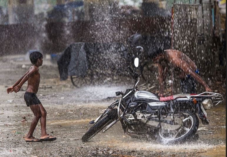 बारिश में मस्ती करता बच्चा