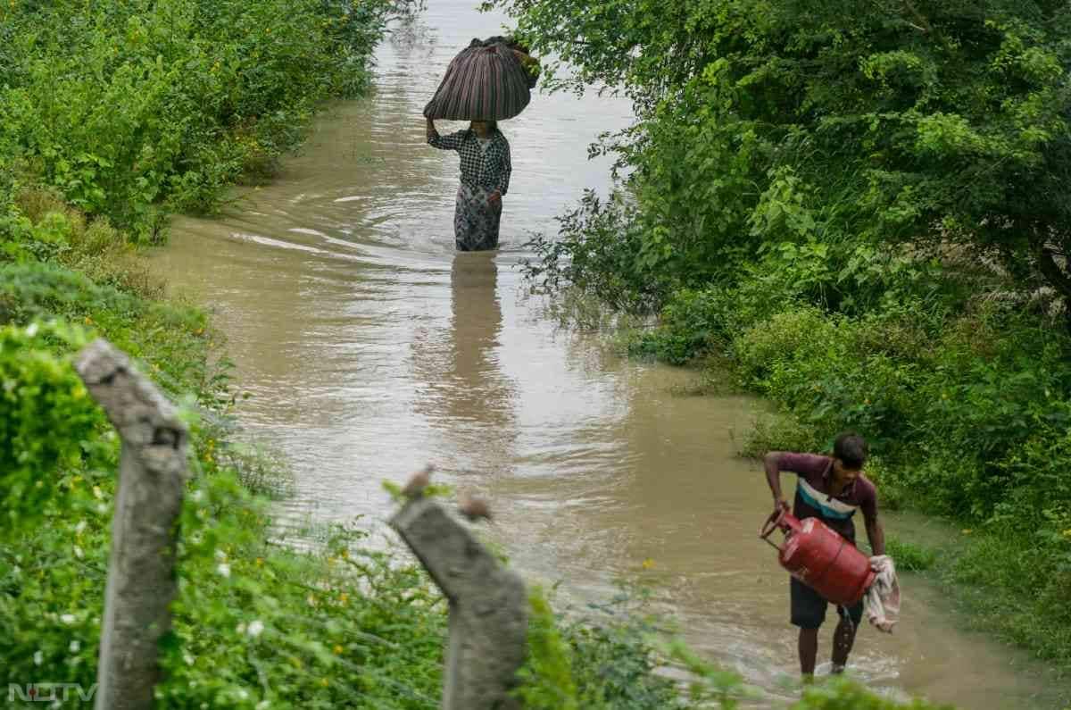 लोगों को सिलेंडर और अन्‍य भारी सामानों को लेकर पानी से भरे रास्‍तों से गुजरना पड़ रहा है.