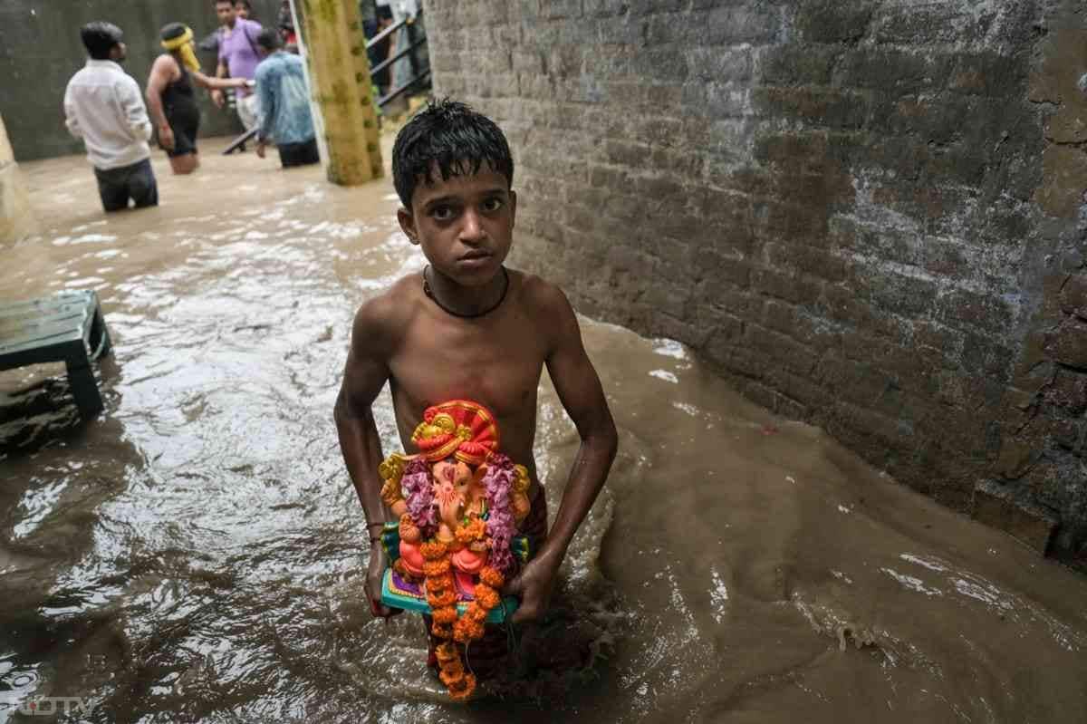 यमुना नदी में जलस्‍तर बढ़ने के कारण लोग अपने घरों को खाली करने पर मजबूर हैं. लोग अपने आराध्‍यों को भी साथ में सुरक्षित स्‍थानों तक लेकर जा रहे हैं.