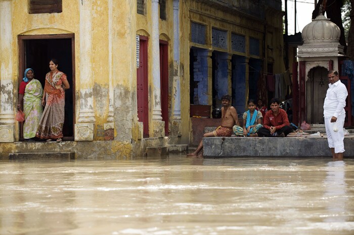 <strong>Stranded:</strong> People at a temple watch the rising waters of the river Yamuna in New Delhi.<br />
<br />
With flood water entering various low-lying areas due to incessant rains, the Delhi government has started evacuation of people residing in these localities and has even sounded an alert.<br />
<br />
According to officials, the situation arrived after Haryana released an additional 93,308 cusecs of water into the Yamuna river. <em>(AFP)</em>