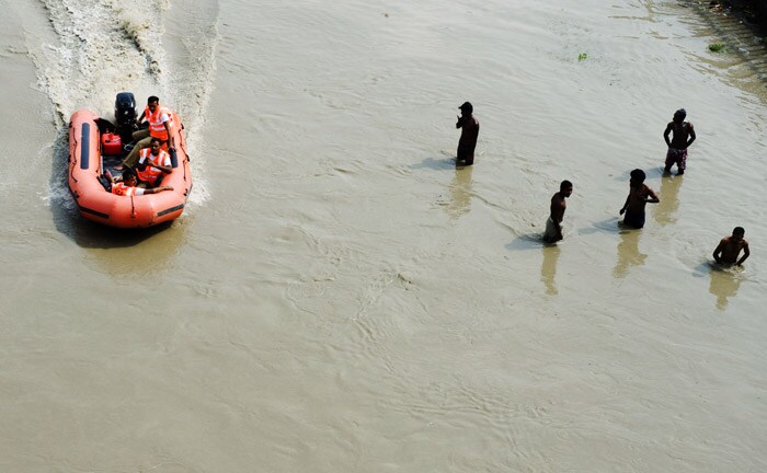 <p><strong>Ready for rescue:</strong> A rescue boat steers past people in flooded river Yamuna in New Delhi.<br />
<br />
For most of the year, the Yamuna is effectively a polluted drain that flows through Delhi. There is little water and mostly pollutants discharge from factories and settlements.<br />
<br />
Now, the Yamuna is overflowing its banks because of the very heavy rains in the area over the last couple of days, and people living in low lying areas face an imminent danger. <em>(AFP)</em></p>