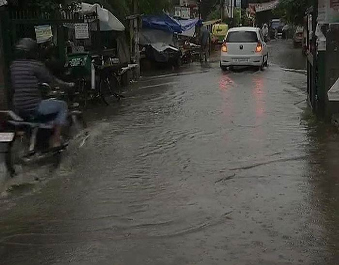 A car wades through a water-logged street in Delhi.