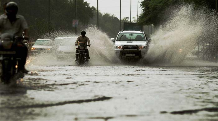 Vehicles wade through a water logged road in New Delhi