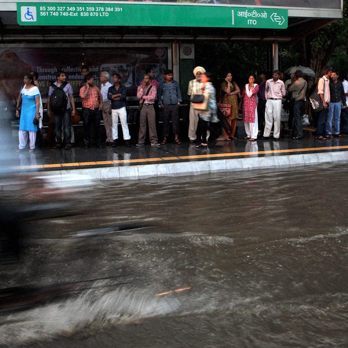 A cyclist wades through a flooded street near a bus stand in New Delhi. The city saw widespread waterlogging despite claims by MCD of having completed de-silting of storm water drains. (PTI Photo)