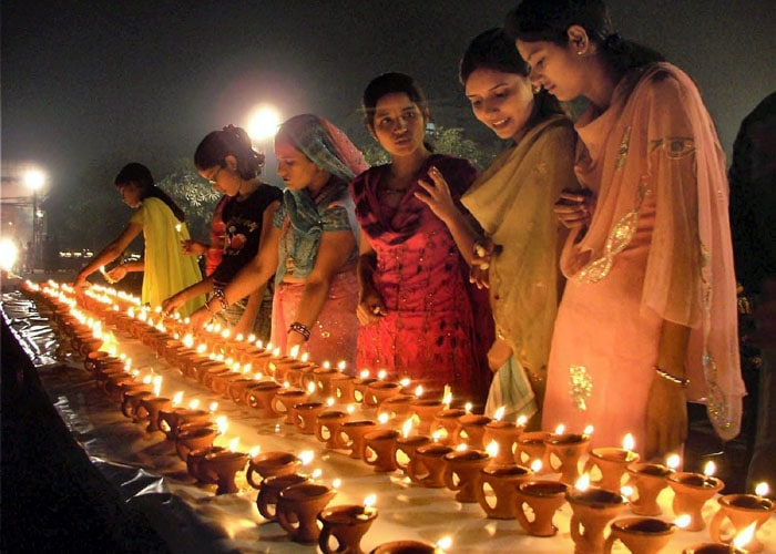 Young girls create a queue of lights. No small task with 1008 diyas to be lit. (PTI Photo)